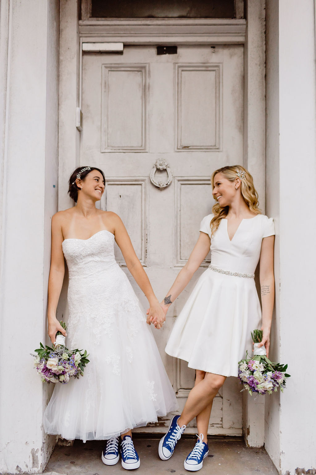 Two brides in white dresses eloping in the French Quarter of New Orleans.
