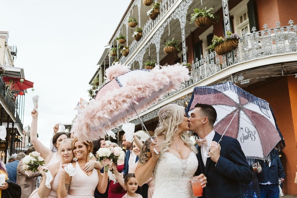 A couple embracing in front of a historic building in New Orleans.