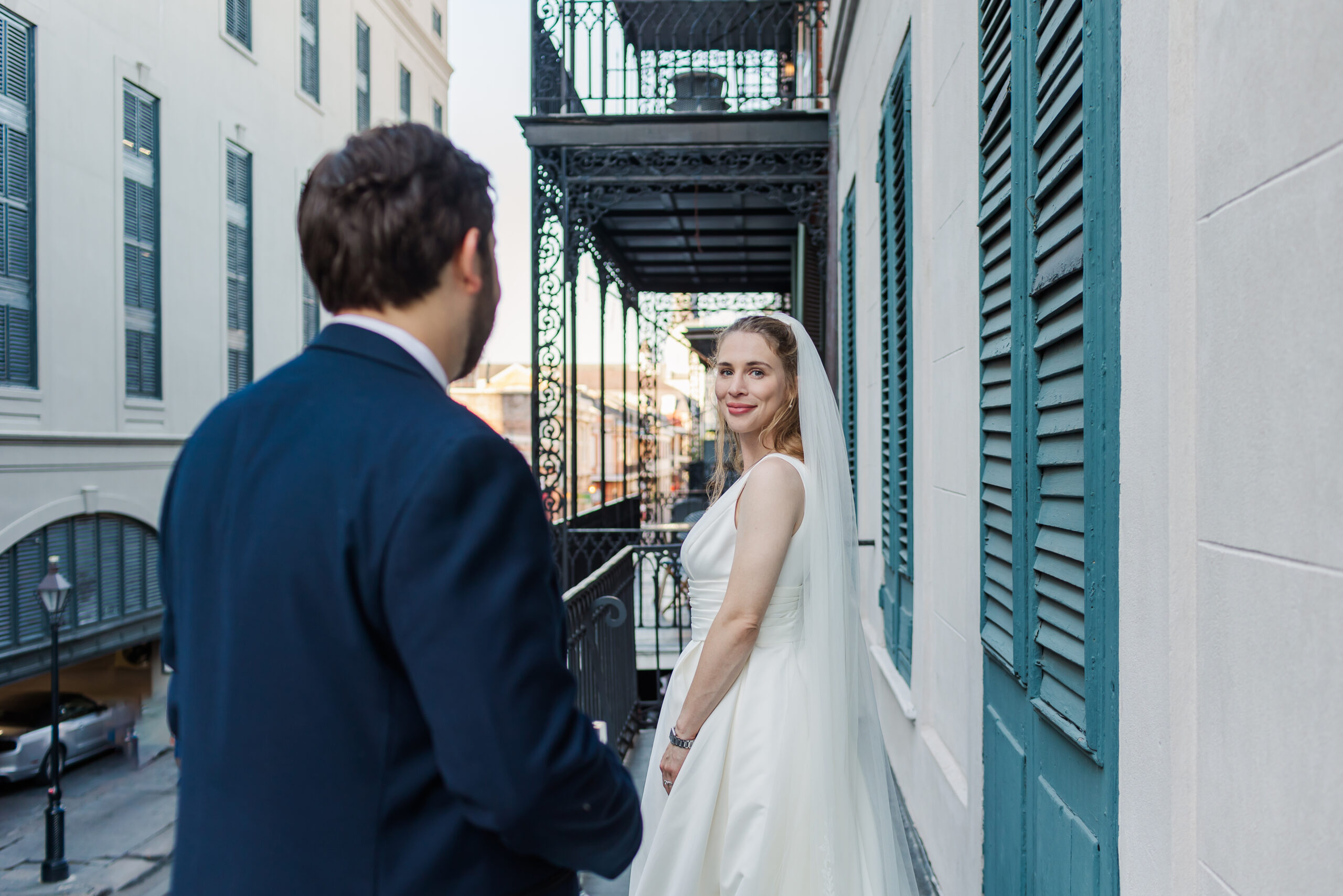 bride looking back at her groom on a French quarter balcony in New Orleans