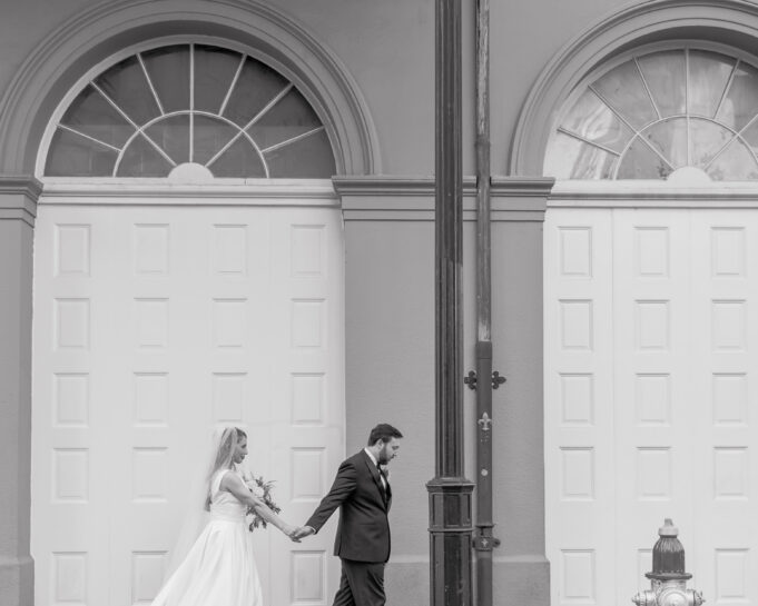 black and white photo of a married couple walking in French quarter New Orleans