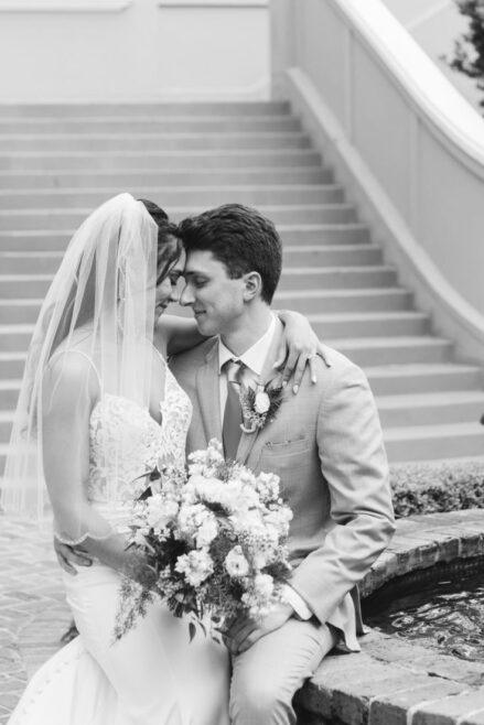 Bride and groom seated by a fountain after their intimate New Orleans wedding.