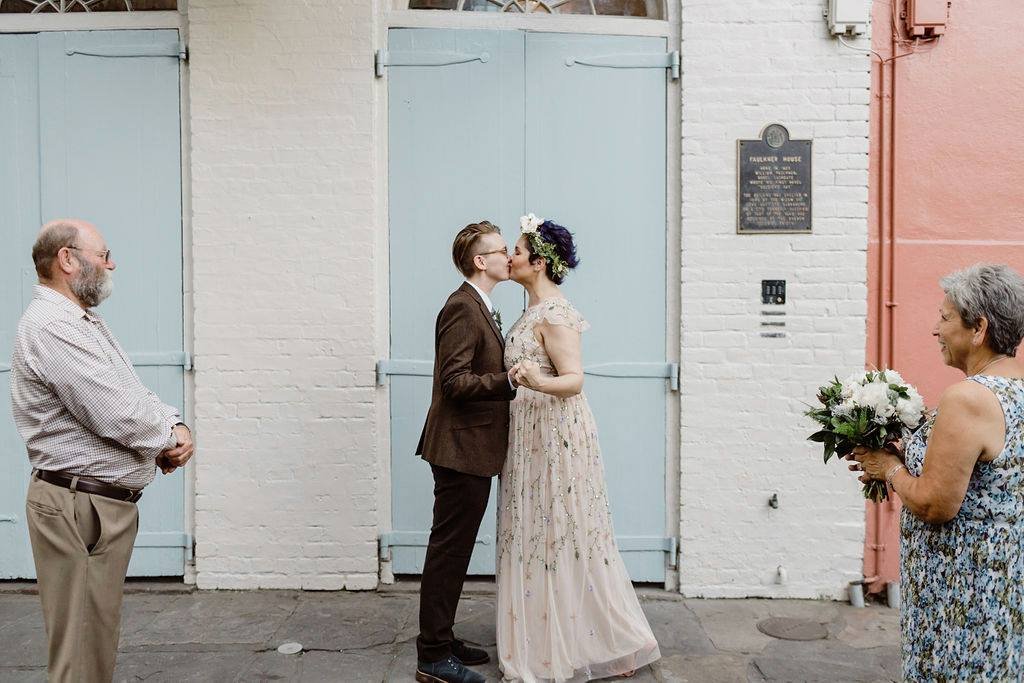 Newlywed couple kissing in a quiet pirates alley after their ceremony.