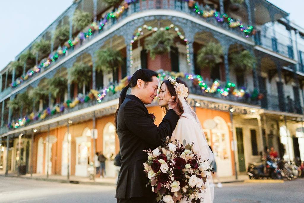 Couple posing in front of a historic landmark in the French Quarter after their New Orleans elopement.