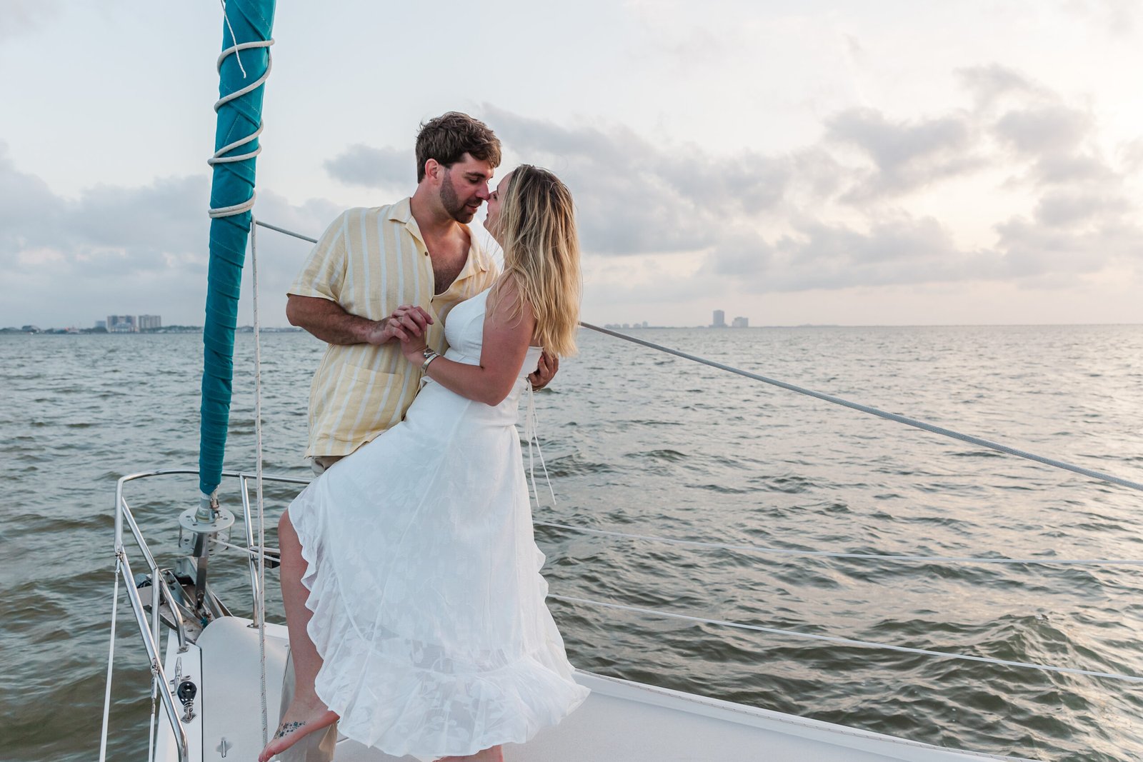 Couple sharing a dip kiss on the bow of a sailboat during their New Orleans elopement