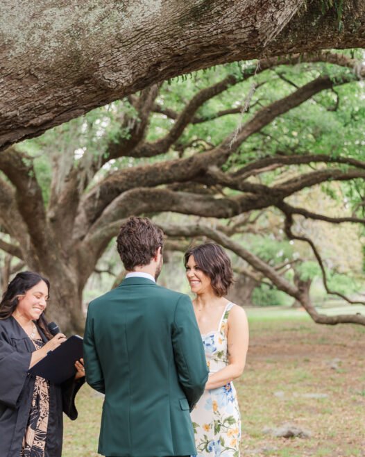 Bride and groom standing under McDonough oak in City Park after eloping