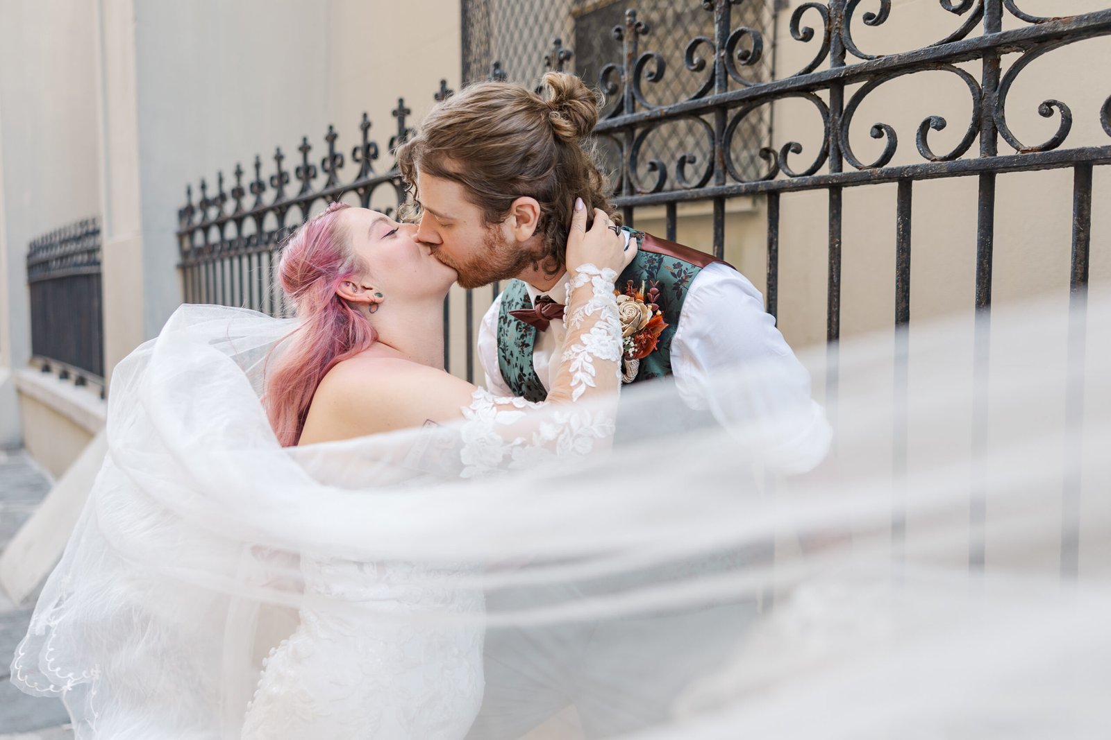 Couple kissing behind a flowing veil during their New Orleans elopement package ceremony.