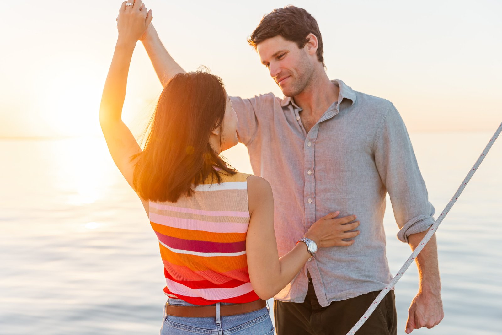 Couple eloping on a sailboat at sunset on Lake Pontchartrain, part of a New Orleans elopement package experience.