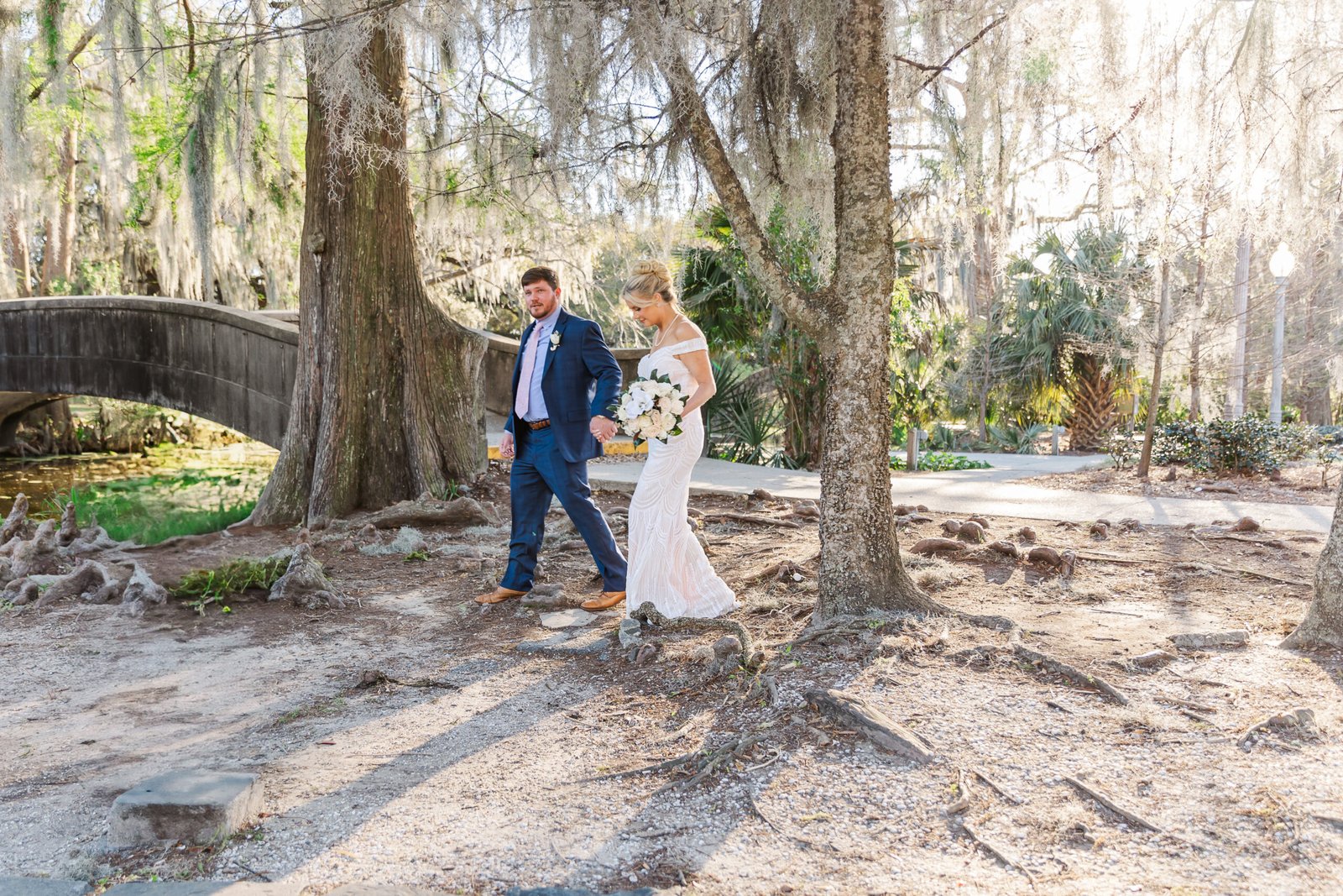 couple walking to their Elopement ceremony in the shade of oak trees in City Park