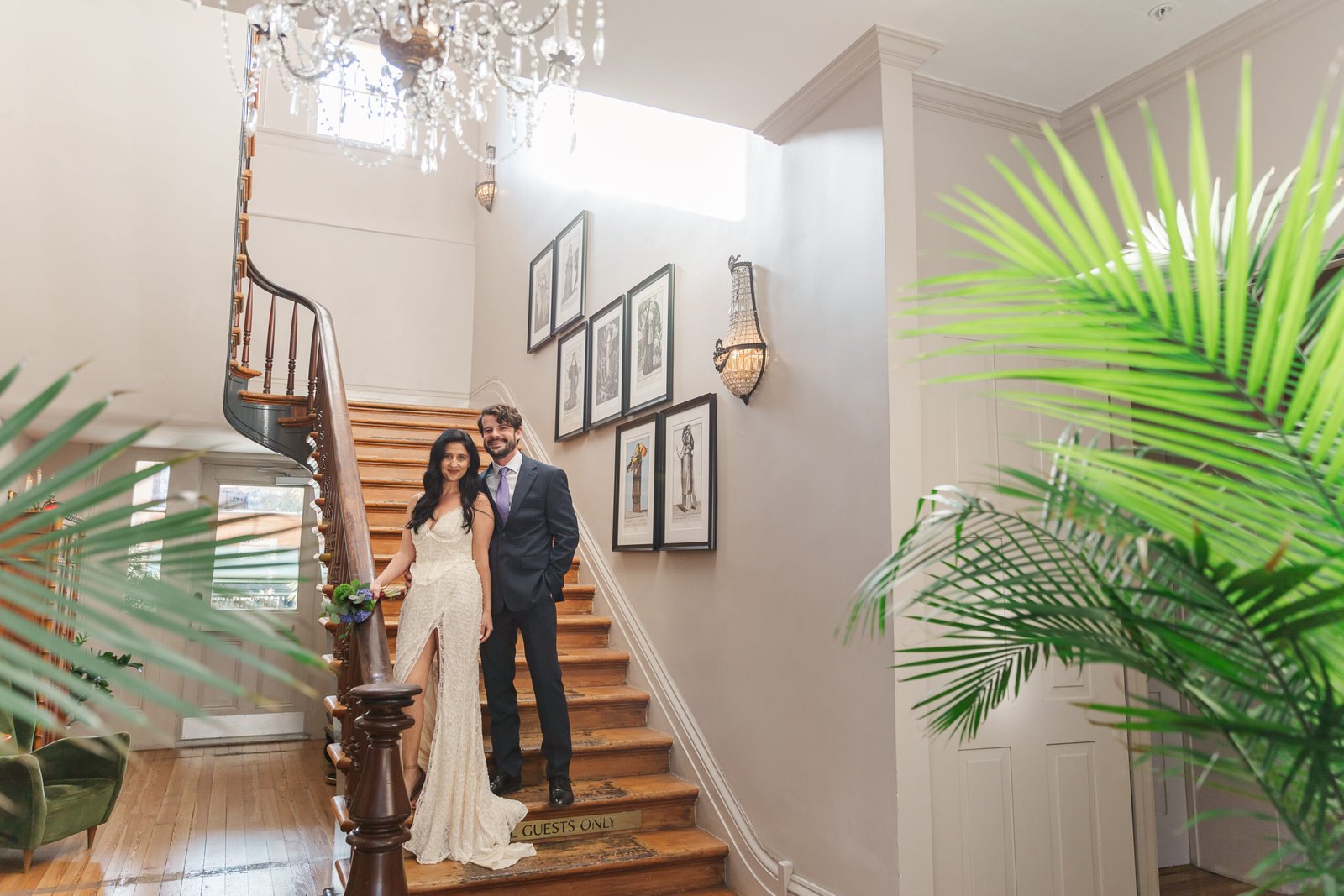 A stylish eloped in New Orleans couple poses on the grand staircase of a historic, design-forward hotel in New Orleans' Garden District.