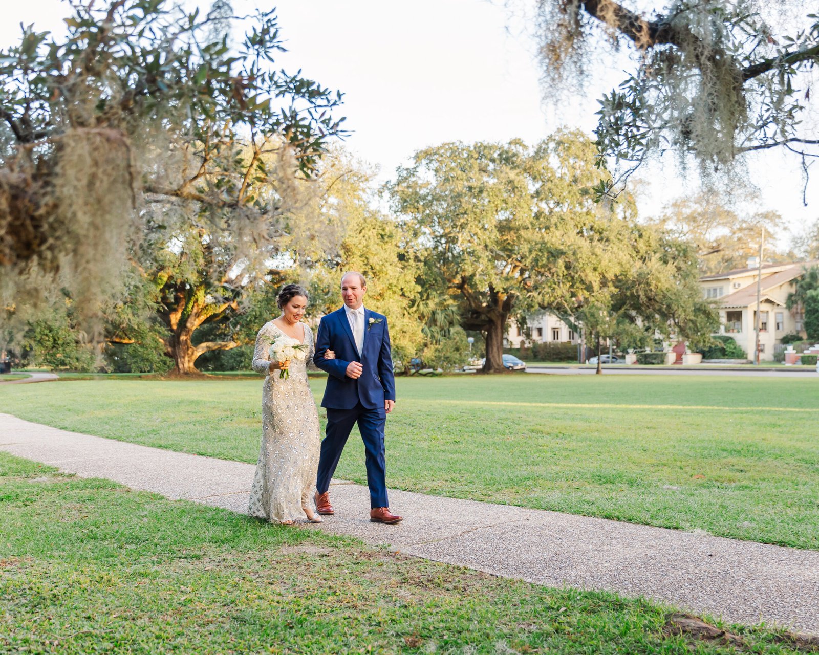 Couple pausing together in front of large oak roots after eloping