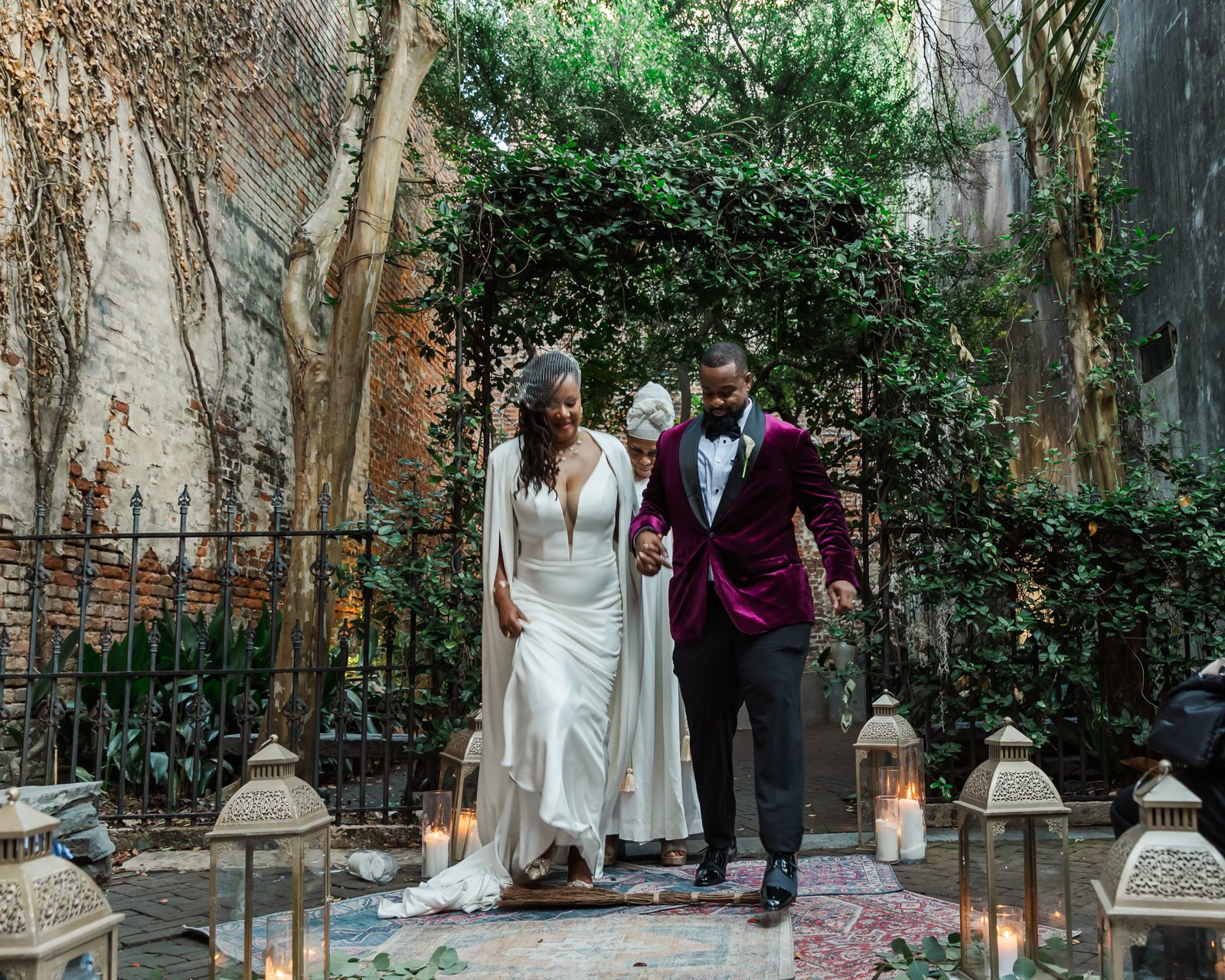Couple jumping the broom at Pharmacy Museum after their destination wedding New Orleans