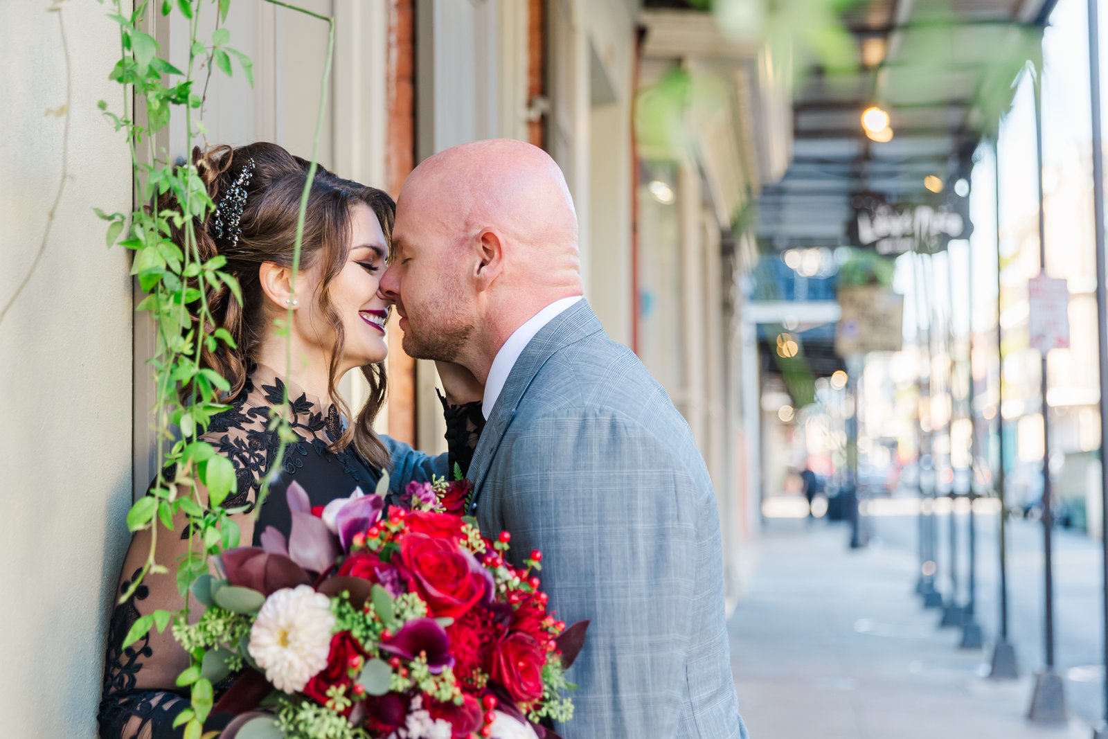 Couple kissing in the French Quarter after their elopement with ivy around them