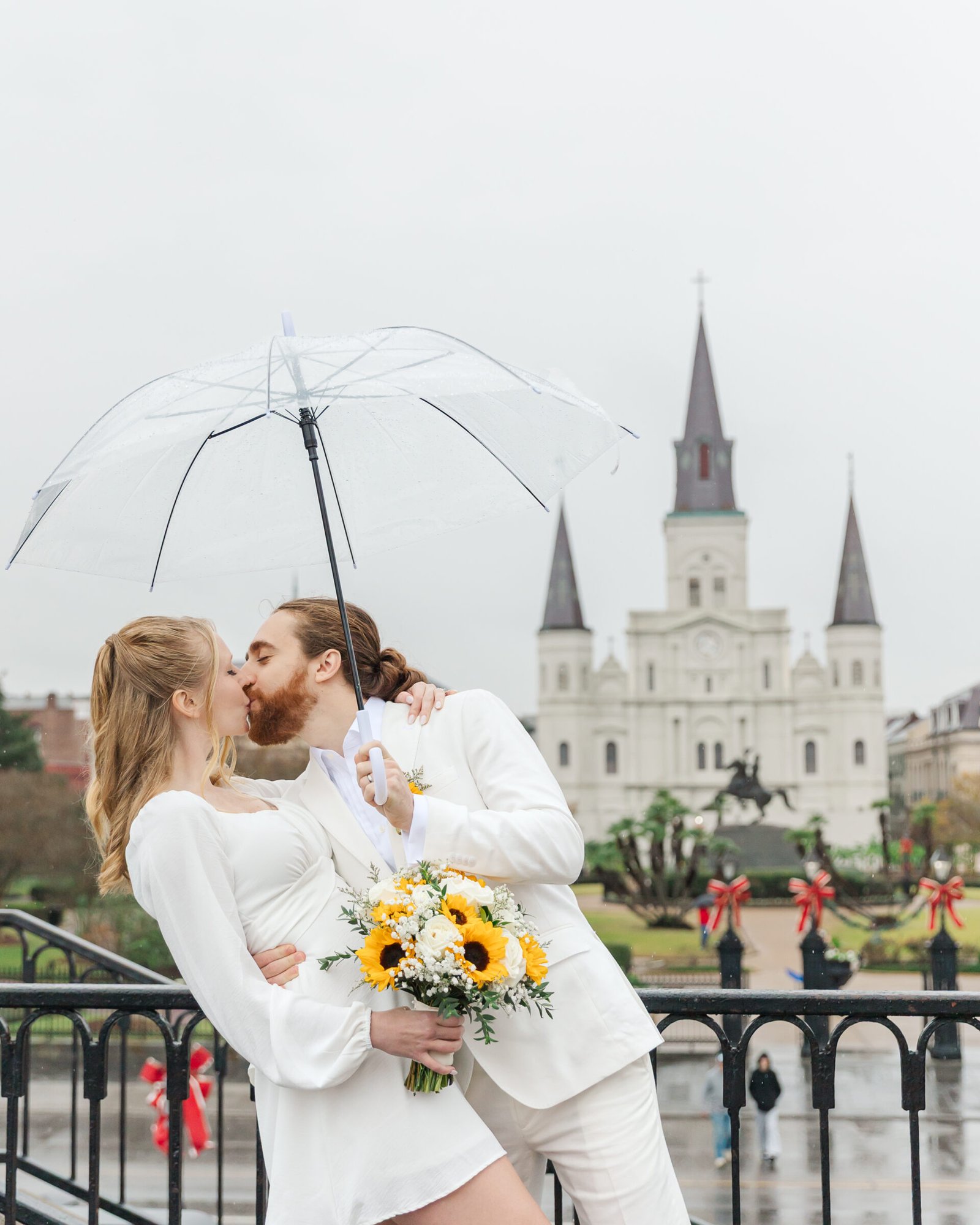 couple kissing in front of Jackson Square for their French quarter elopement on a rainy day