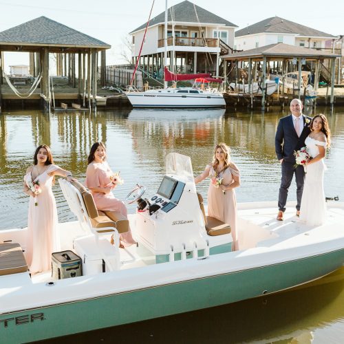 A group of bridesmaids and groomsmen on a boat, exploring the picturesque New Orleans City Park.